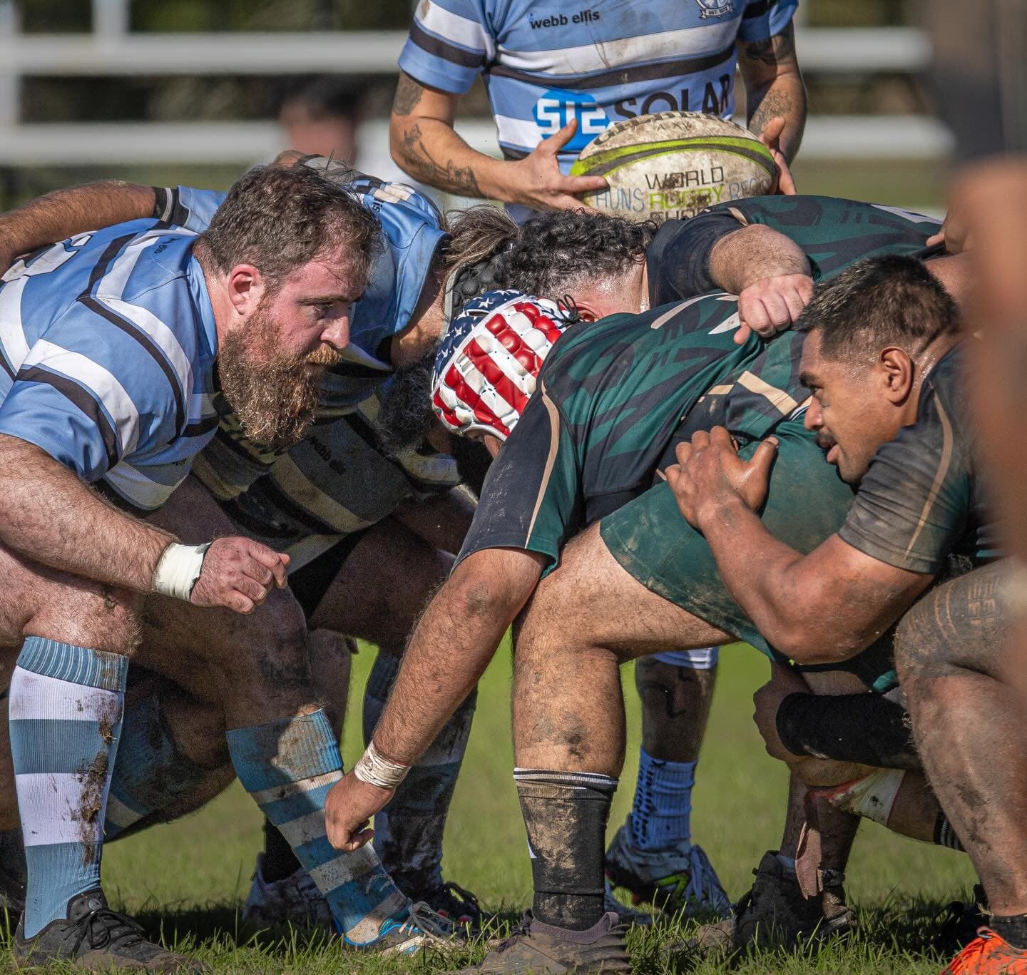 Muddy forwards packing down in a scrum during a local grassroots rugby club match